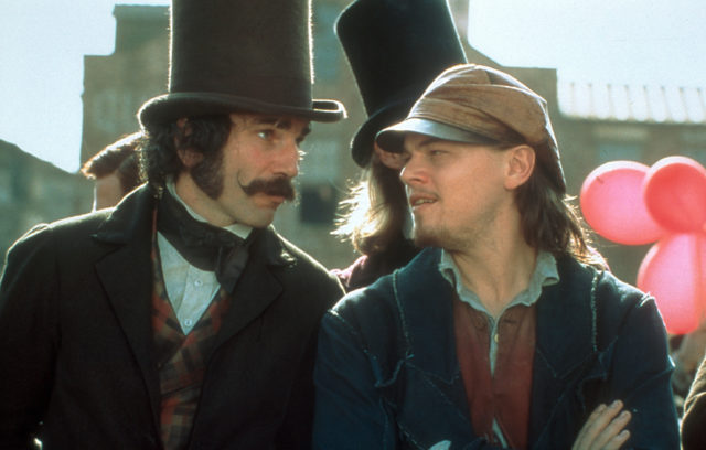 Daniel Day-Lewis as Bill the Butcher in a top hat and jacket, and Leonardo Dicaprio as Amsterdam Vallon in a peaked hat.