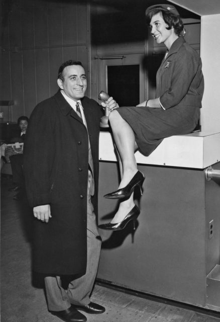 American singer Tony Bennett serenades a TWA air hostess at the airport