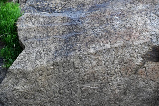 A photo of a stone with markings etched into it.