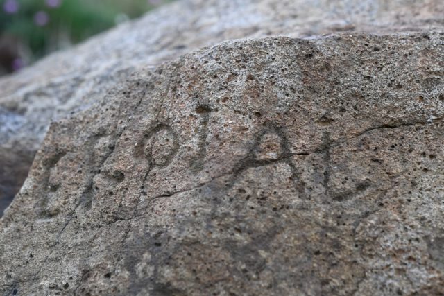 A close up of a stone with markings carved into it.