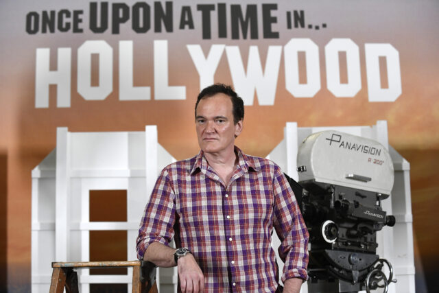 Quentin Tarantino in front of an orange backdrop