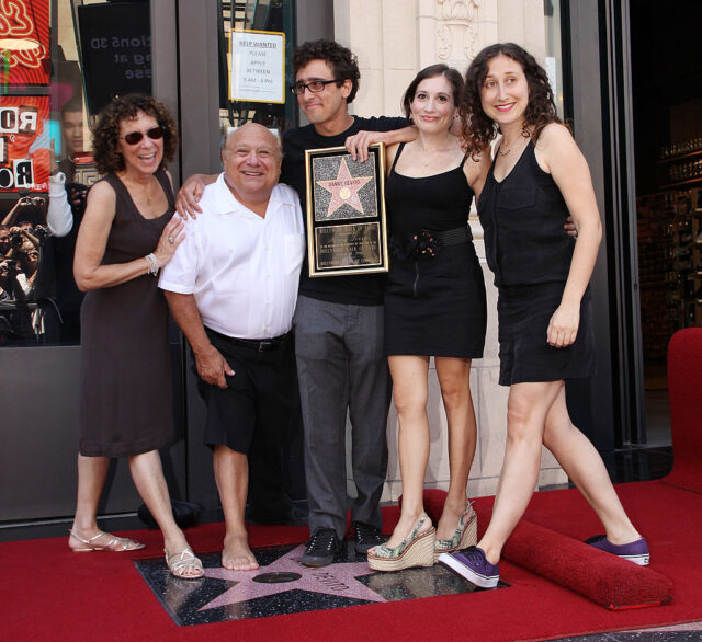 Rhea Perlman, Danny Devito, and their three children, pose with Devito's star on the Hollywood Walk of Fame.
