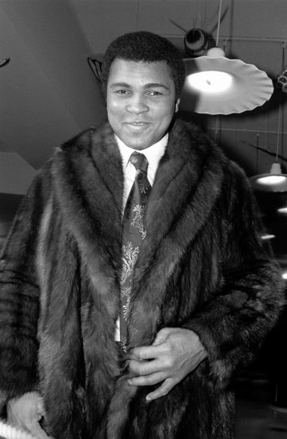 Portrait of American Heavyweight boxer Muhammad Ali dressed in a fur coat during a men's fur fashion show