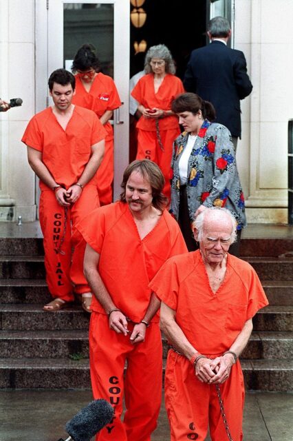 Procession of Branch Davidians walking down a set of stairs in orange jumpsuits. 