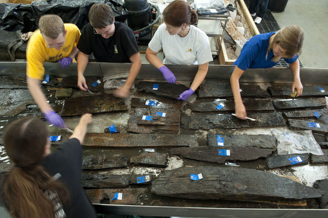 Volunteers from the Maryland Archaeological Conservation Laboratory cleaning pieces of wood