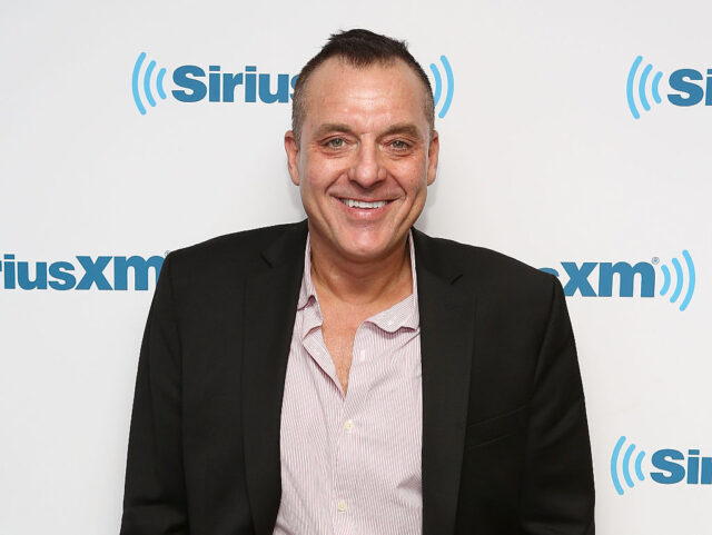 Tom Sizemore smiling in a black jacket and light shirt. 