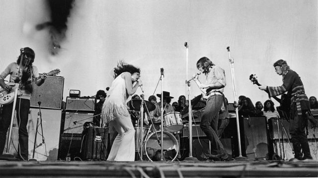 Jefferson Airplane performing on stage with fans in the background.