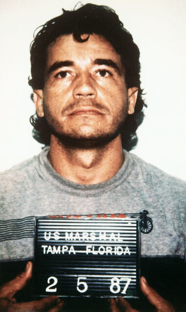 John List in a grey t-shirt holding a police placard. 