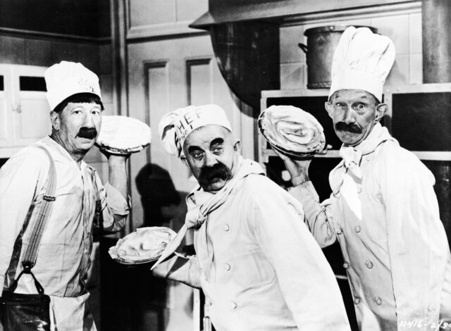 Three actors, portraying chefs, prepare to throw pies in a 1947 movie still. 