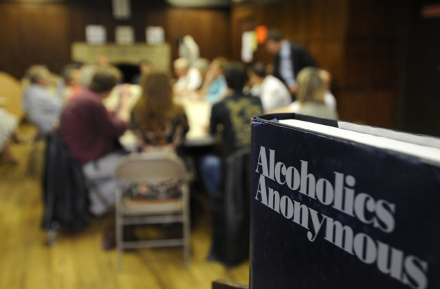 Group sitting around a table at an Alcoholics Anonymous meeting