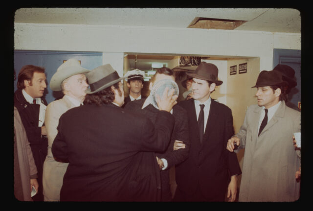 John Belushi pushes a pie into Bull Murray's face in a skit, satirizing the assassination of Lee Harvey Oswald, on Saturday Night Live. The scene is depicted in the same way as the real assassination. 