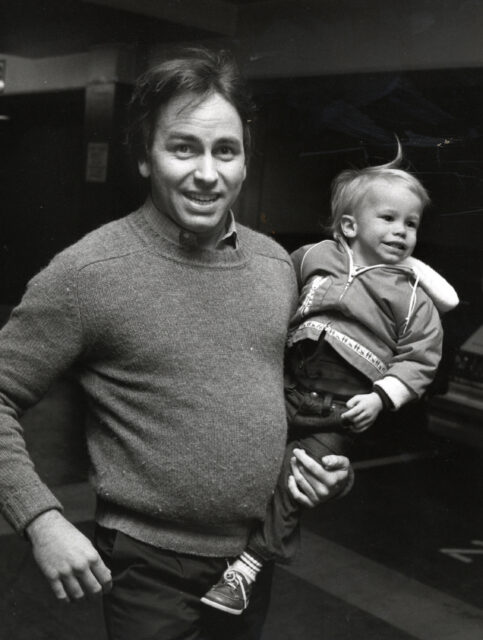 John Ritter carrying son Jason Ritter on his hip.