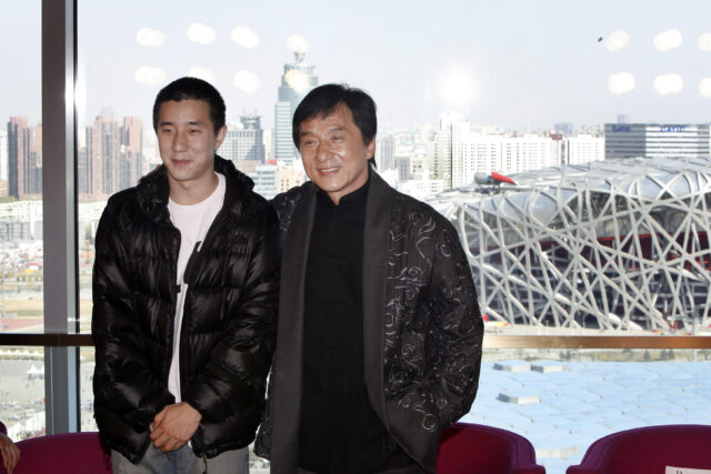Jackie Chan posing with his son, Jaycee Chan, for a photo.