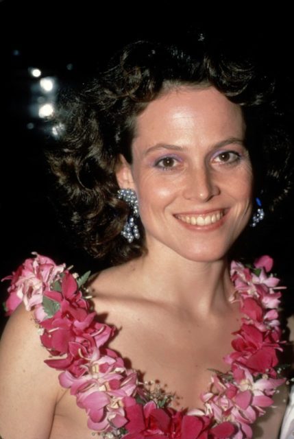 Sigourney Weaver attends a party wearing a pink lei