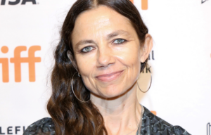 Justine Bateman at a red carpet event in front of a white backdrop