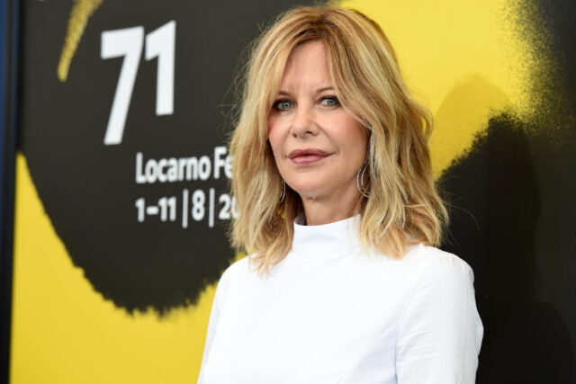 Meg Ryan poses in front of a yellow poster