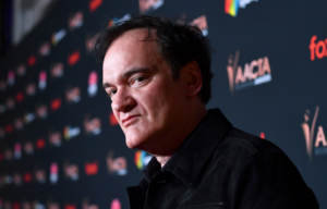 Headshot of Quentin Tarantino looking at the camera from the side.