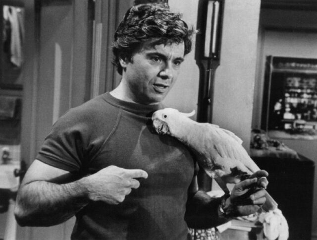 Robert Blake holding a parrot on his arm.