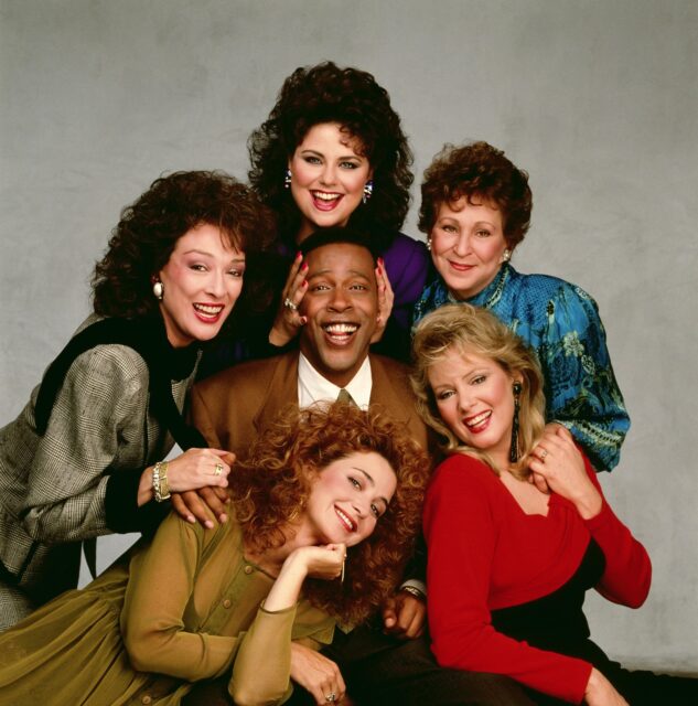 Dixie Carter, Annie Potts, Jean Smart, Delta Burke, and Alice Ghostley all surrounding Meshach Taylor smiling.