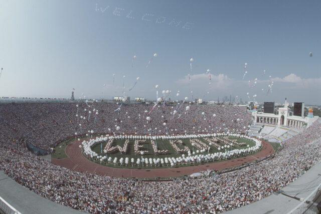 Performers spell out Welcome on the stadium infield as balloons are released above them during the opening ceremony for the XXIII Olympic Games on 28 July 1984 at the Los Angeles Memorial Coliseum in Los Angeles, California, United States.