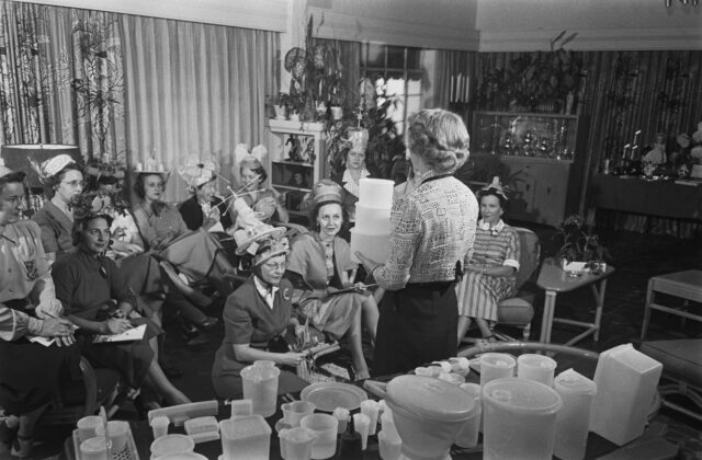 Woman holding Tupperware containers in front of other women