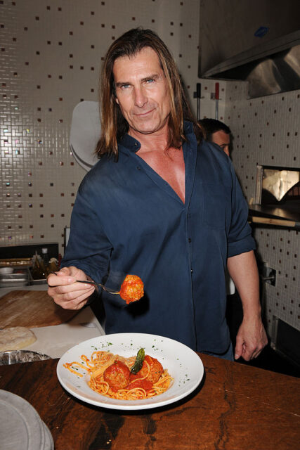 Fabio Lanzoni eating a plate of spaghetti and meatballs at a restaurant