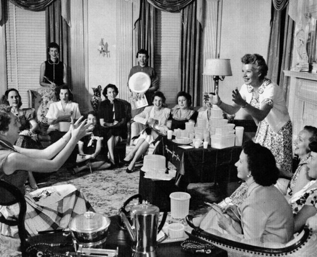 Brownie Wise tossing a Tupperware container to a woman while others watch