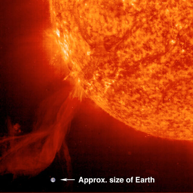 Photo of a solar prominence erupting from the sun in 2002 with the earth added for scale. 