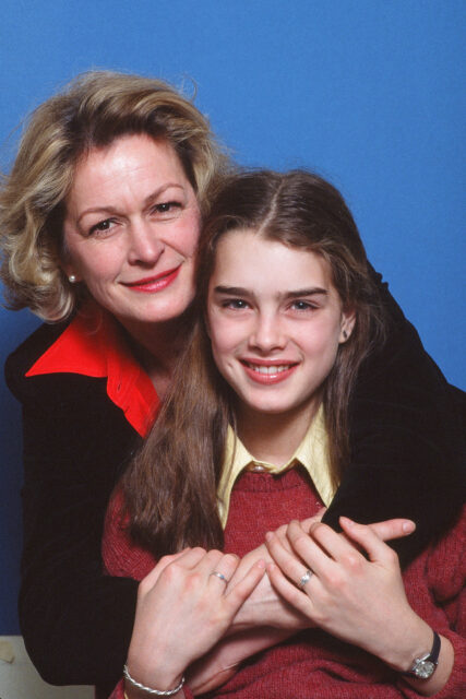 A portrait of Brooke and Teri Shields, Teri hugging her daughter from behind.