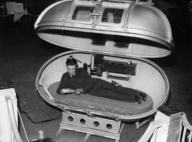 Man lying in a metal pod.