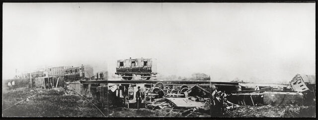 Individuals standing around a derailed train