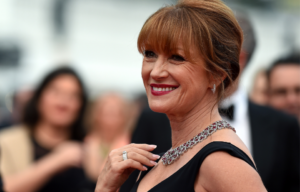Photo of Jane Seymour holding her hand to her collarbone, smiling.