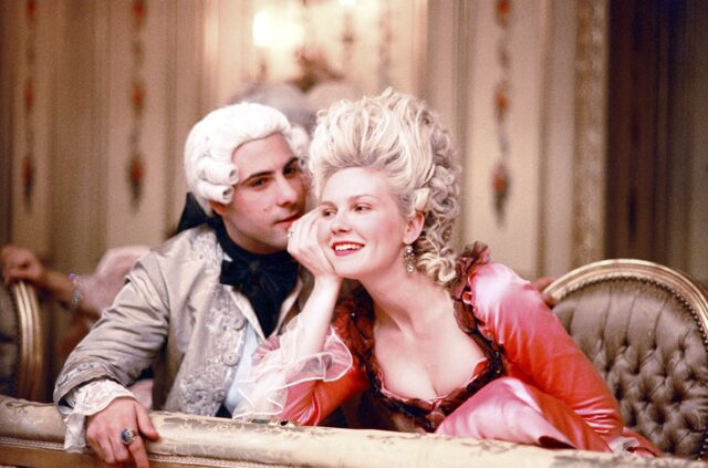 Jason Schwartzman, in a powdered wig, and Kirsten Dunst, both seated in regal period costumes.
