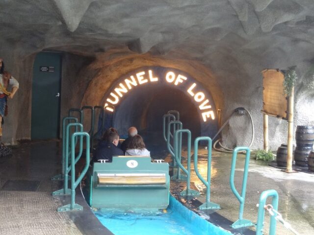 A boat with riders entering a Tunnel of Love.