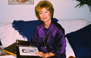 Linda Lee Cadwell holding a photo album