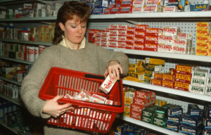 Woman placing boxes of Tylenol in a shopping basket