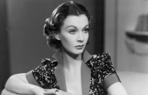 Vivien Leigh looking into the distance with her arms resting on something in front of her.