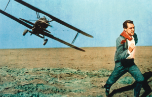 Cary Grant running through a field with a low-flying plane chasing him.