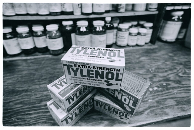 Three boxes of extra-strength Tylenol stacked together on a wooden table
