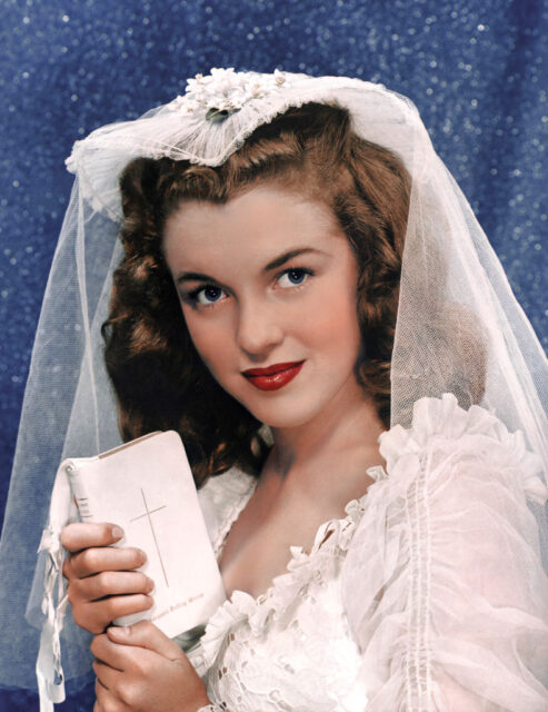 Portrait of Marilyn Monroe wearing a wedding dress and holding a Bible