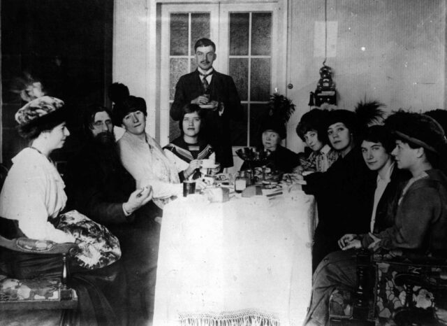 Grigori Rasputin, Praskovya Fedorovna Dubrovina, and Maria Rasputin sitting together for tea with a large group.