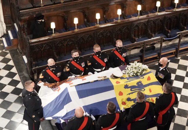 Queen Elizabeth II look on as her late husband, Prince Philip's coffin is brought into St. George's Chapel by eight Royal Marine pallbearers.