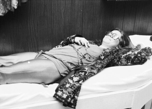 Janis Joplin laying on a bed.