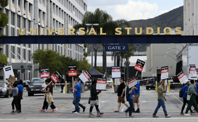 Writers Guild of America (WGA) members holding picket signs outside of Universal Studios