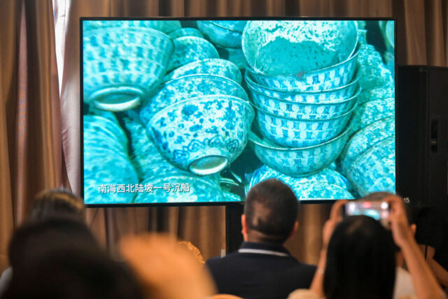 View of a screen showing stacked porcelain bowls underwater.