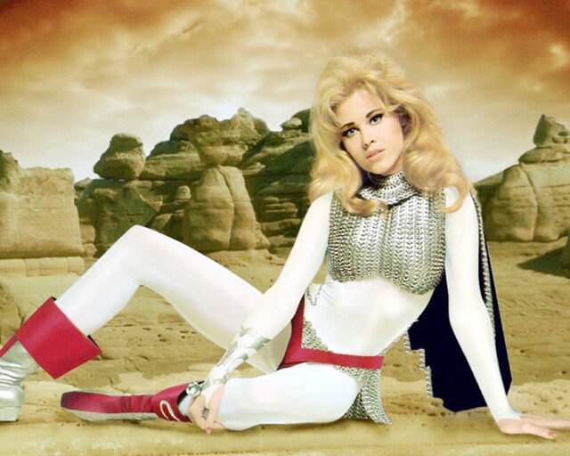 Jane Fonda sitting on her side in costume for "Barbarella"