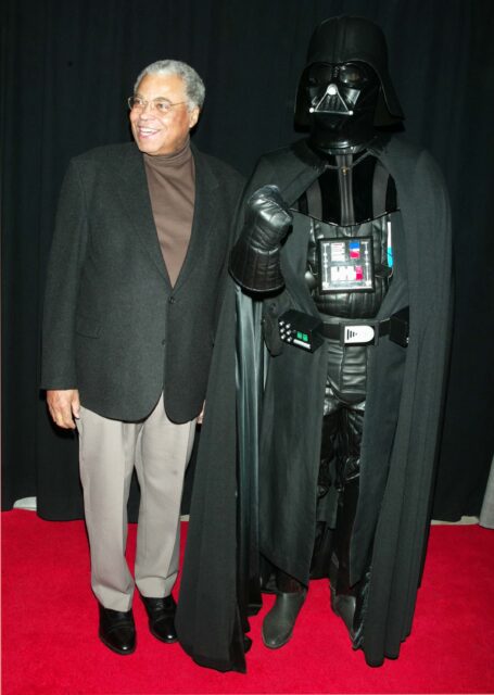 James Earl Jones standing beside an individual dressed as Darth Vader