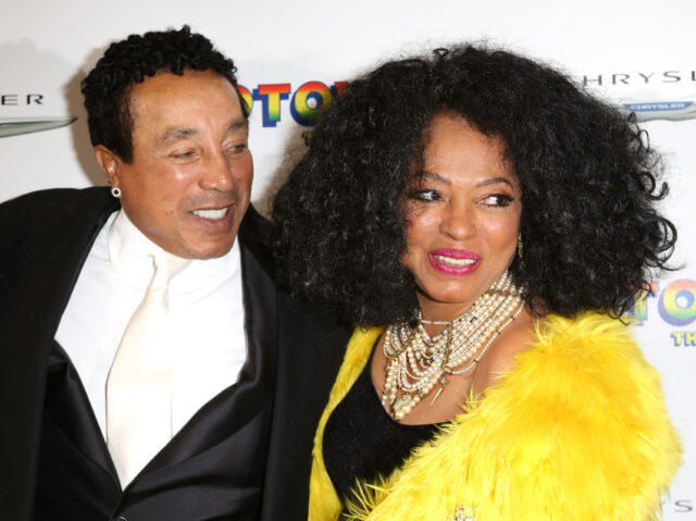 Smokey Robinson looking at Diana Ross as they pose for a photo together.