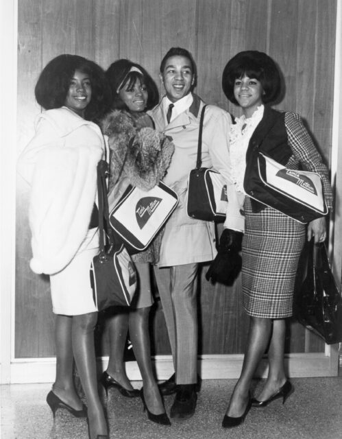 The Supremes posing for a photo with Smokey Robinson.