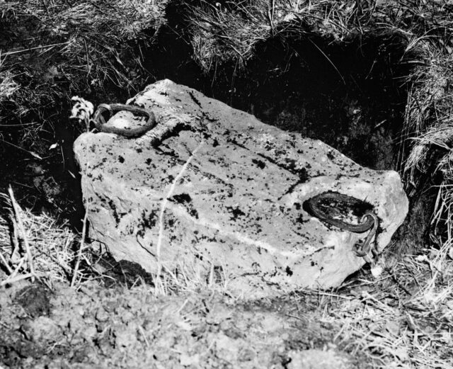 Photo of the Stone of Destiny laying in grass.